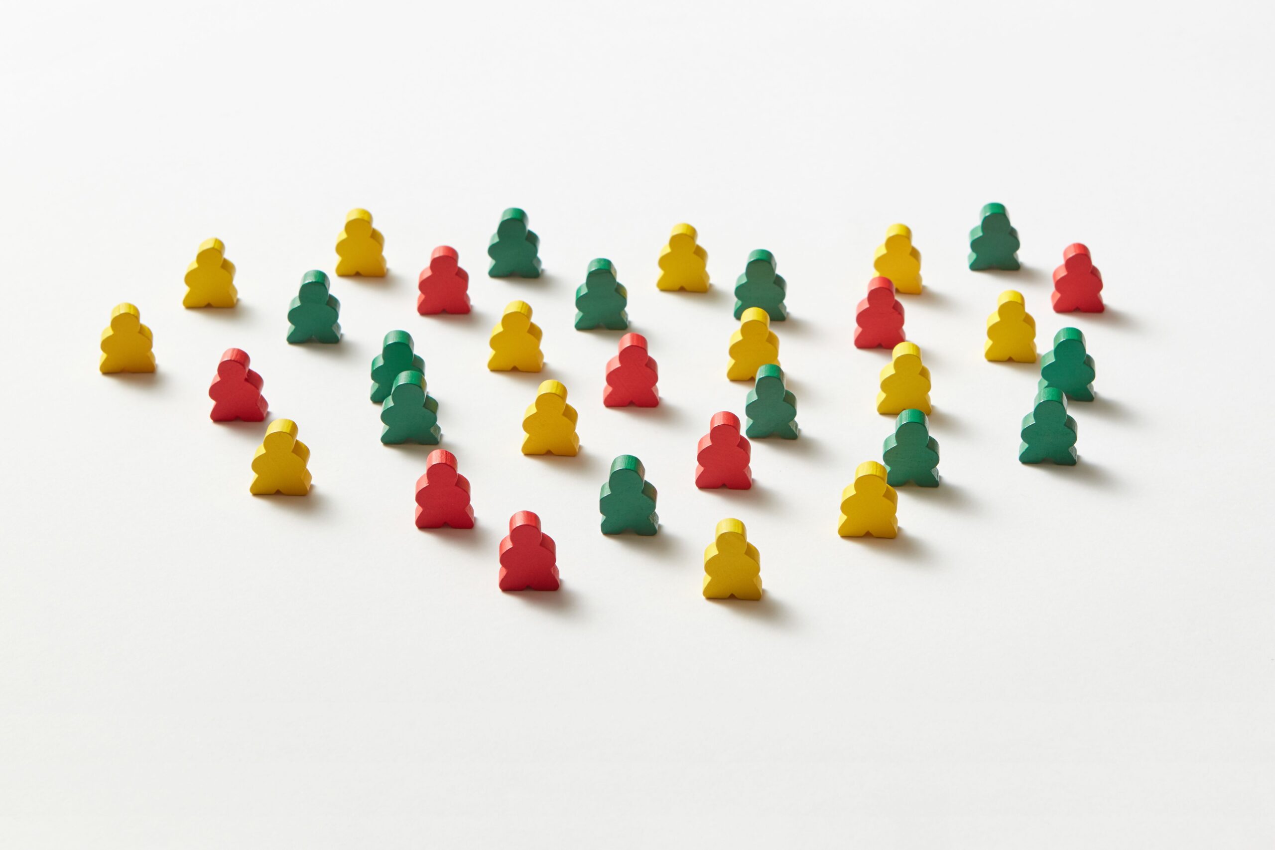 Colorful red, yellow, and green board game pieces arranged on a white background.